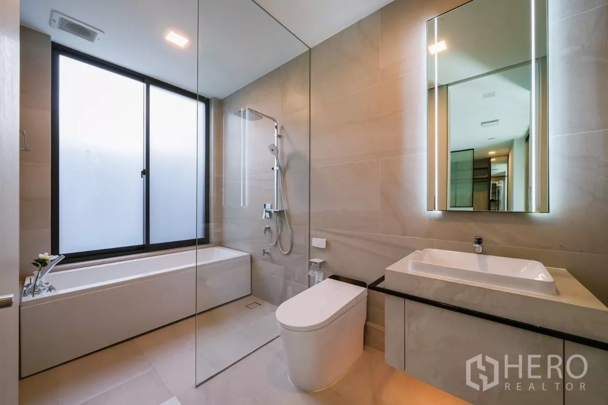 บ้าน ให้เช่าหรือขายในSaphan Sung, Bangkok - ห้องน้ำสว่างพร้อมอ่างอาบน้ำ ฝักบัวกระจก และกระจกไฟ LED