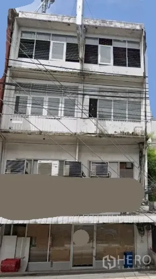 อาคารพาณิชย์ ให้เช่าในKhlong Toei, Bangkok - อาคารพาณิชย์ 4 ชั้น ด้านหน้าเป็นกระจกกว้าง มีหน้าต่าง ระเบียง เครื่องปรับอากาศหลายเครื่อง และสายไฟเหนือถนน ย่านคลองเตย ใกล้บีทีเอสพระโขนง