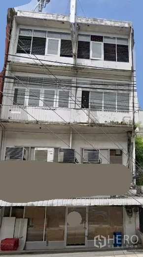 อาคารพาณิชย์ ให้เช่าในKhlong Toei, Bangkok - อาคารพาณิชย์ 4 ชั้น ด้านหน้าเป็นกระจกกว้าง มีหน้าต่าง ระเบียง เครื่องปรับอากาศหลายเครื่อง และสายไฟเหนือถนน ย่านคลองเตย ใกล้บีทีเอสพระโขนง