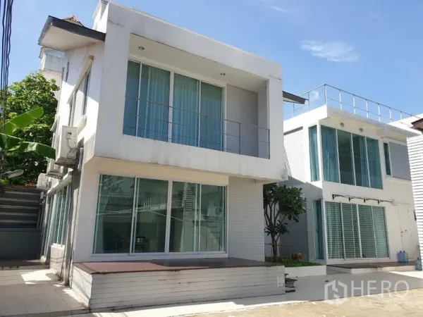 Detached House for rent in Khlong Toei, Bangkok - Modern white two-storey detached house with large windows and driveway in the Sukhumvit area.