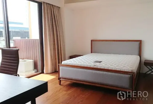 คอนโด ขายในPathum Wan, Bangkok - ห้องนอนหลักสว่างไสว เตียงบุผ้า พื้นไม้ และทางออกสู่ระเบียง