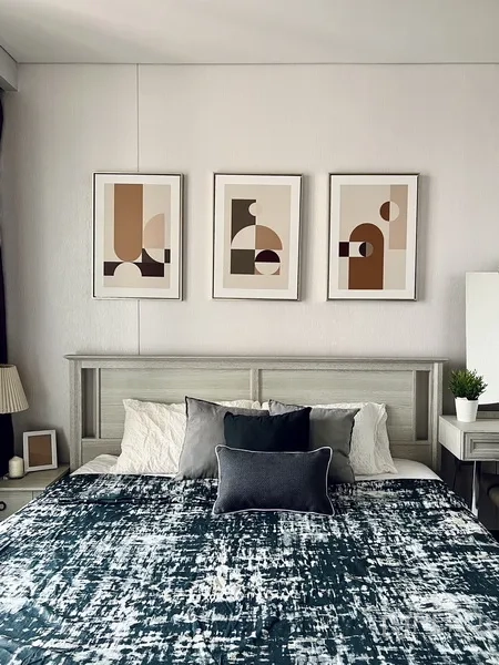 คอนโด ให้เช่าหรือขายในKhlong Toei, Bangkok - เตียงนอนสไตล์โมเดิร์น มีกรอบรูปนามธรรมสามชิ้น โต๊ะข้างเตียงและโต๊ะเครื่องแป้ง