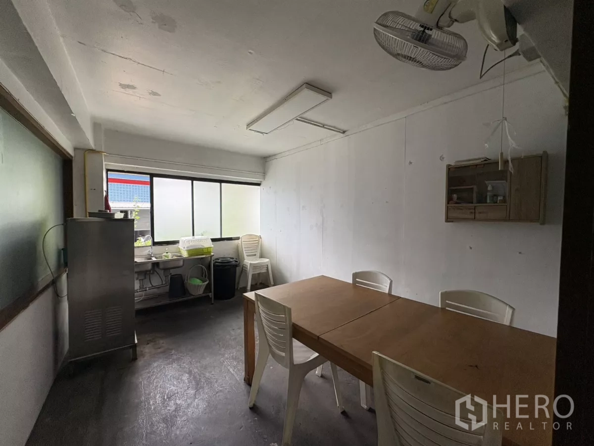 办公空间 出租在Watthana, Bangkok - 紧凑的茶水间/休息室，配桌椅、水槽和窗户。