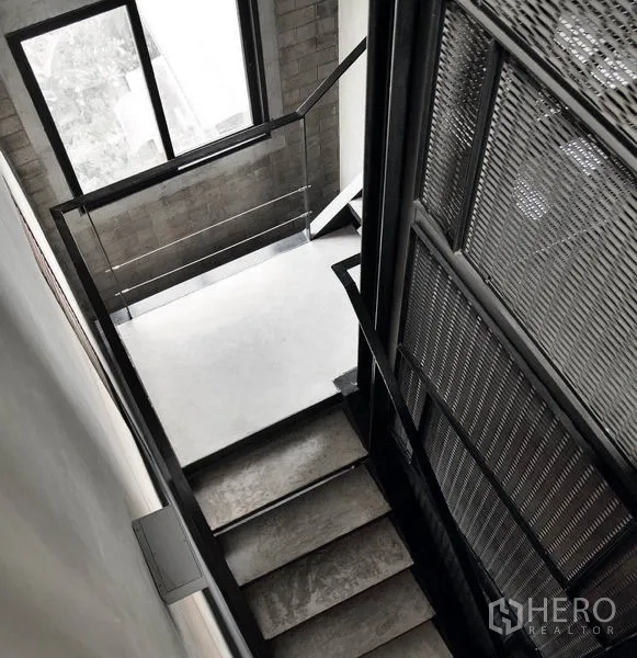 Office Space for rent in Phaya Thai, Bangkok - Industrial staircase with metal mesh screen, concrete steps, and a large window in a loft-style office building.