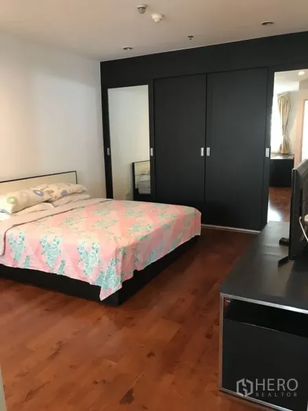 Condominium for rent in Watthana, Bangkok - Master bedroom with large wardrobes, TV console and wooden flooring