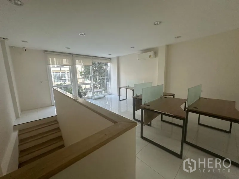 带办公室的家 出租在Bang Na, Bangkok - 楼上开放式工位区，摆放办公桌并面向大面积玻璃与阳台。