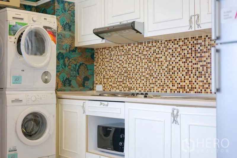 คอนโด ให้เช่าในKhlong Toei, Bangkok - ครัวขนาดกะทัดรัด ตู้สีขาว ผนังกระเบื้องโมเสก เตา ฮูด ไมโครเวฟ และเครื่องซัก–อบซ้อน