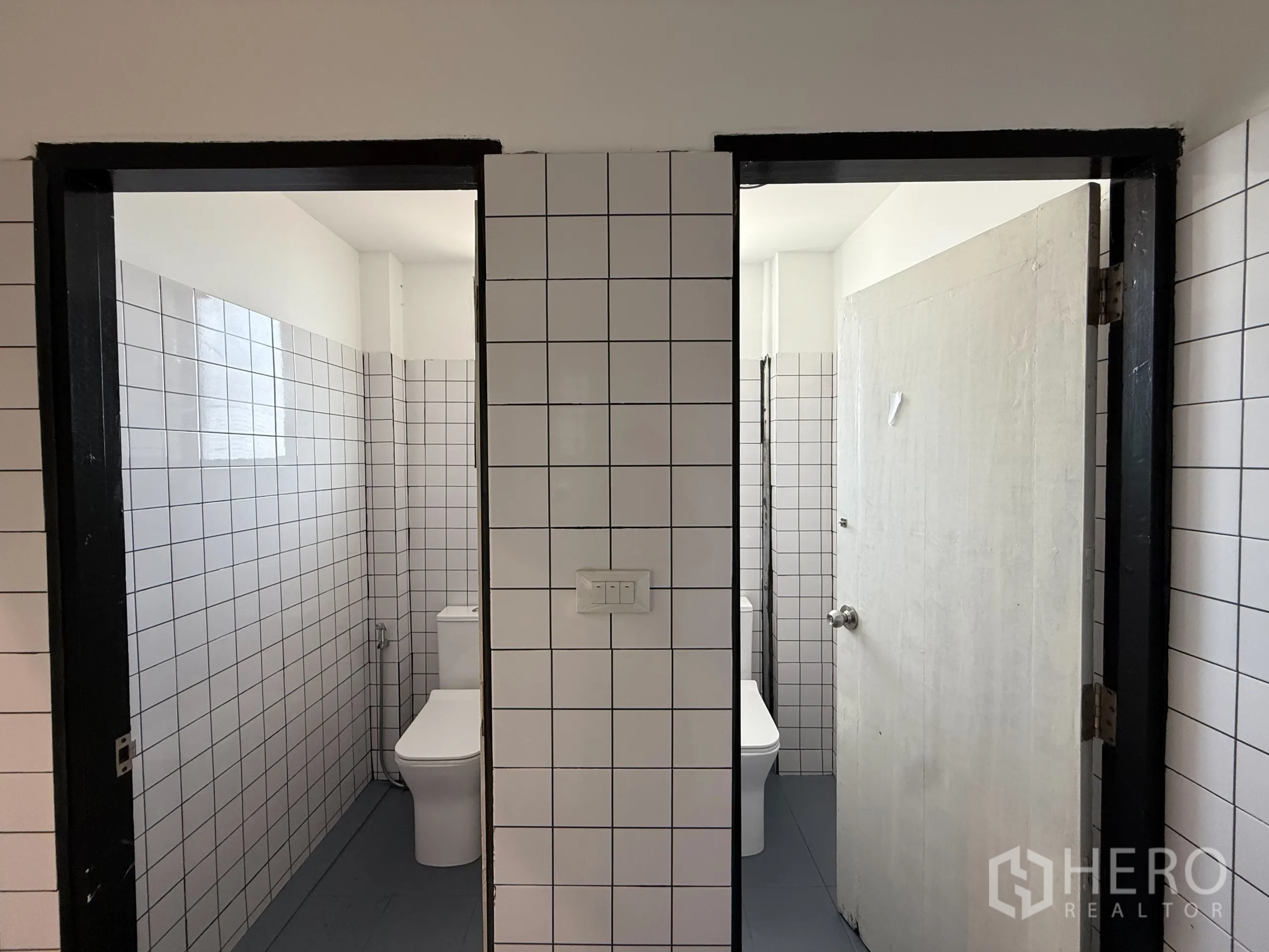 Office Space for rent in Wang Thonglang, Bangkok - Modern tiled restrooms with two cubicles and white fixtures.