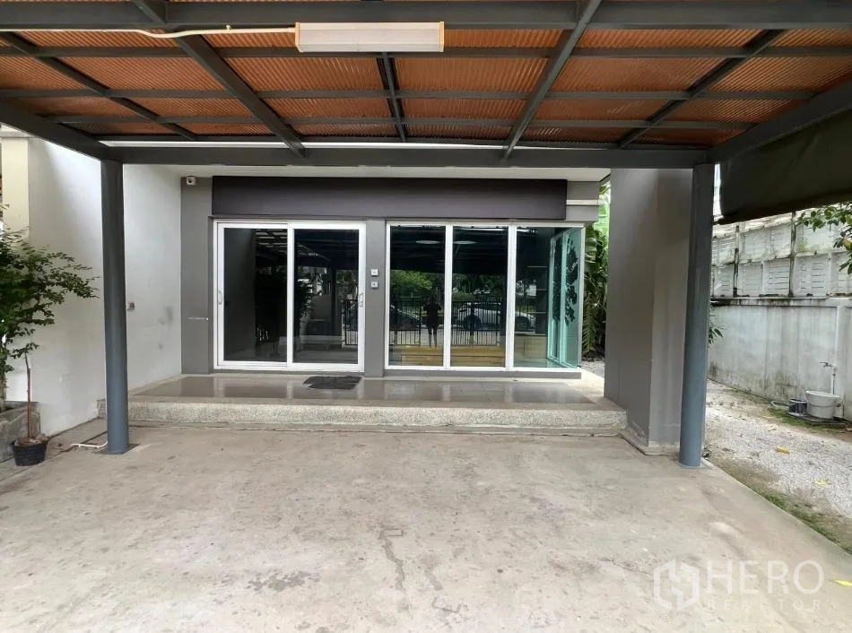 Detached House for rent or sale in Don Mueang, Bangkok - Covered carport facing sliding glass doors to the showroom.