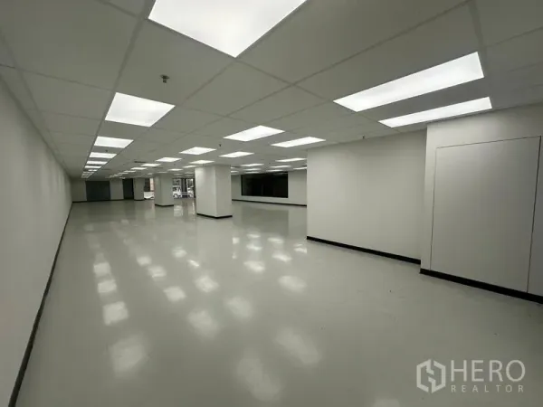 办公空间 出租在Phaya Thai, Bangkok - 长方形办公室，整齐布置的LED灯，少量立柱与侧向窗户。