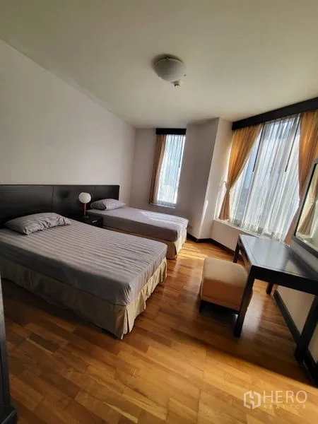 คอนโด ให้เช่าในPathum Wan, Bangkok - ห้องนอนสว่าง เตียงเดี่ยวสองเตียง โต๊ะทำงาน และหน้าต่างมุมห้อง