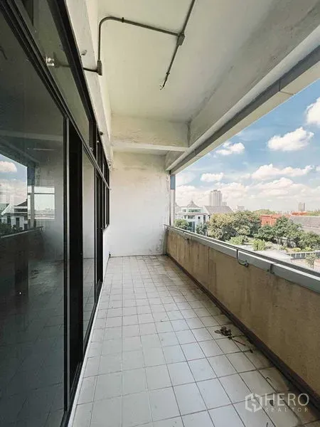 零售空间 出租在Yan Nawa, Bangkok - 上层带顶棚的瓷砖阳台，临玻璃立面，眺望城市景观。