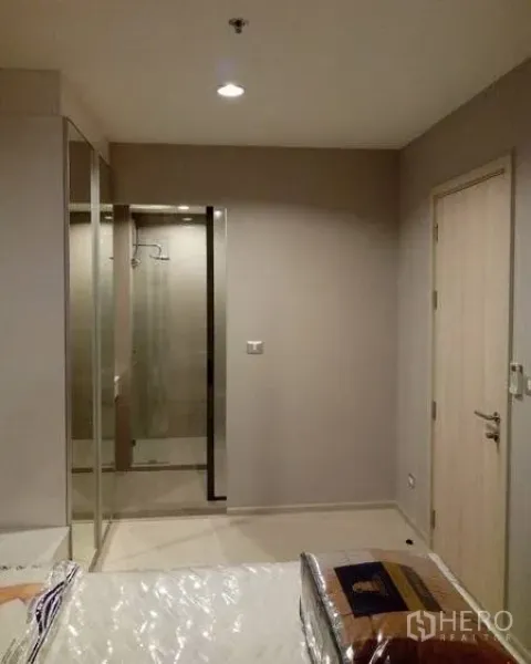 คอนโด ให้เช่าในKhlong Toei, Bangkok - มุมห้องนอนพร้อมตู้เสื้อผ้าบานกระจกและทางเข้าห้องน้ำที่กั้นกระจกฝักบัวแยกเป็นสัดส่วน
