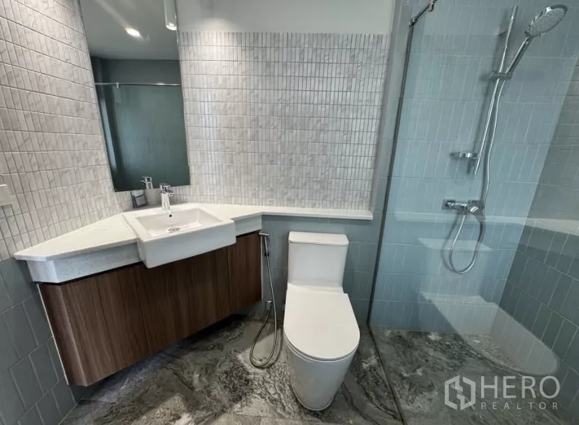 独立式住宅 出租在Watthana, Bangkok - 第二浴室，玻璃淋浴、方形白砖与木质柜体。