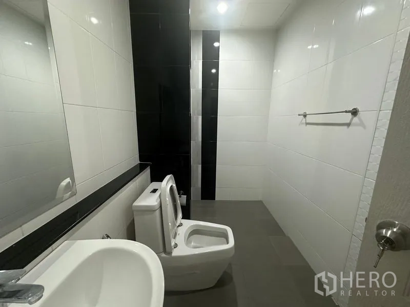 带办公室的家 出租在Bang Na, Bangkok - 现代化卫浴，含洗手盆、坐便器、妇洗器与白色墙砖。