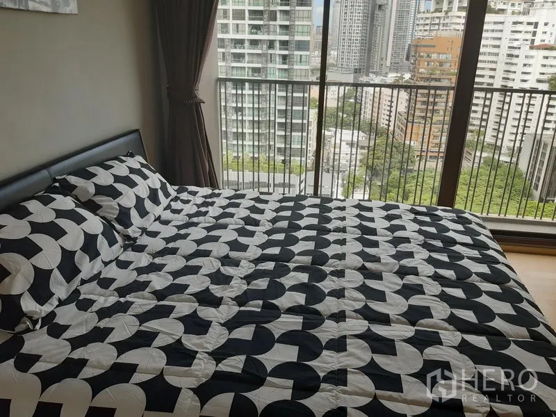 คอนโด ให้เช่าในBangkok - เตียงคิงไซซ์ข้างประตูกระจกบานเลื่อน มุมมองเมืองชั้นสูง