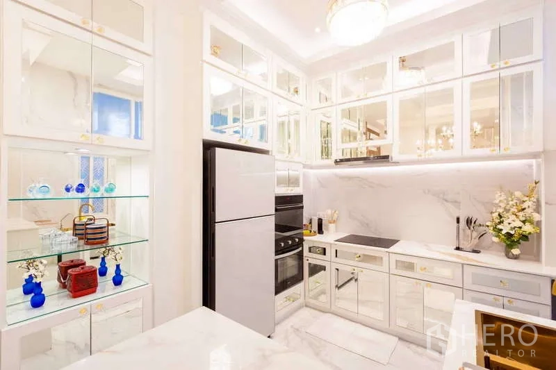 联排别墅 出租在Lat Phrao, Bangkok - 现代白色厨房，镜面橱柜、嵌入式烤箱和玻璃陈列架