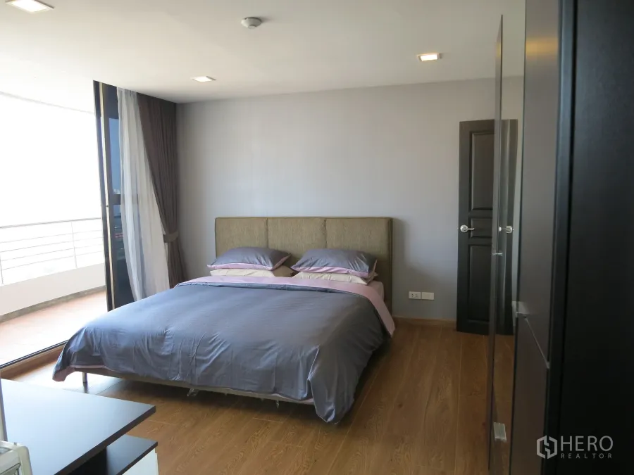 คอนโด ให้เช่าหรือขายในWatthana, Bangkok - ห้องนอนสว่างพื้นไม้ เตียงคิง และประตูกระจกบานเลื่อนเปิดออกสู่ระเบียง