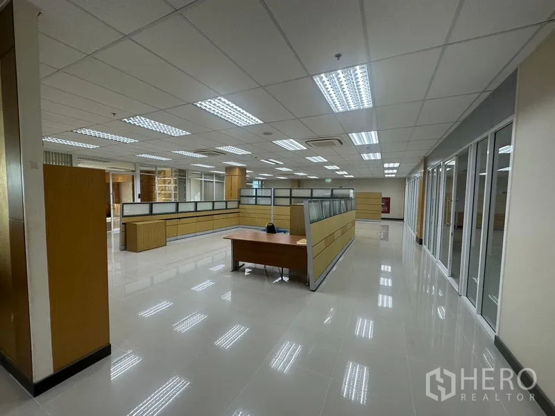 Office Space for rent in Suan Luang, Bangkok - Spacious workspace with workstations, glass walls and a central desk.