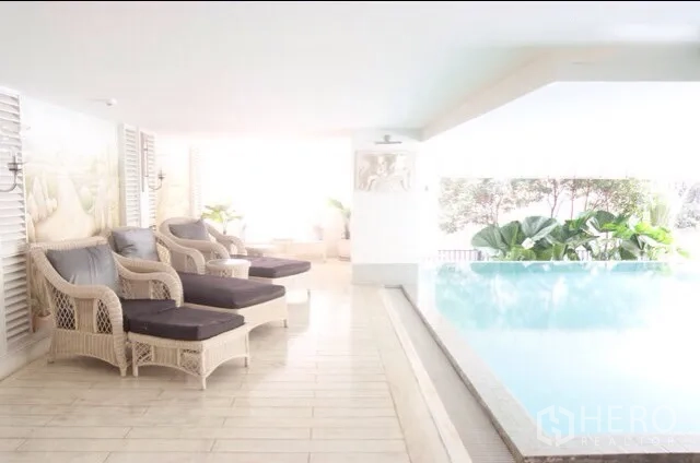 คอนโด ให้เช่าหรือขายในWatthana, Bangkok - สระว่ายน้ำแบบครอบคลุม พร้อมเตียงอาบแดดและต้นไม้ทรอปิคัล