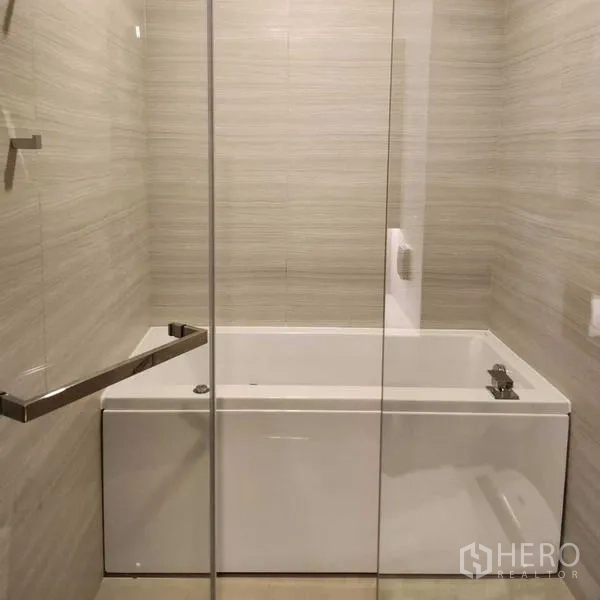 คอนโด ให้เช่าในWatthana, Bangkok - ห้องน้ำสมัยใหม่พร้อมอ่างอาบน้ำกั้นกระจกและผนังกระเบื้องโทนอ่อน