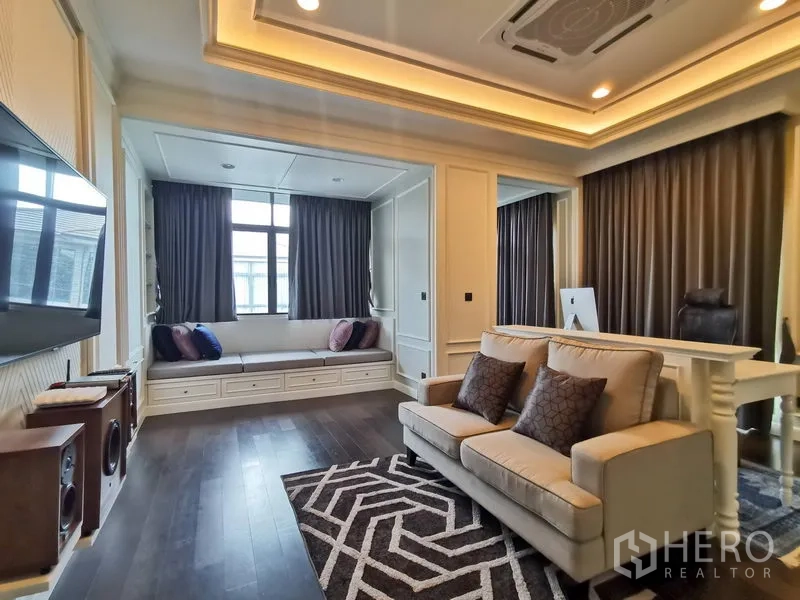 Detached House for rent or sale in Bang Kapi, Bangkok - Home office and lounge with sofa, work desk, recessed ceiling lights, and window seat nook.