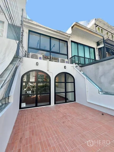 สำนักงานที่บ้าน ให้เช่าในKhlong Toei, Bangkok - ลานระเบียงด้านหลังปูกระเบื้องสีอิฐ พร้อมประตูกระจกโค้งและบันไดข้าง