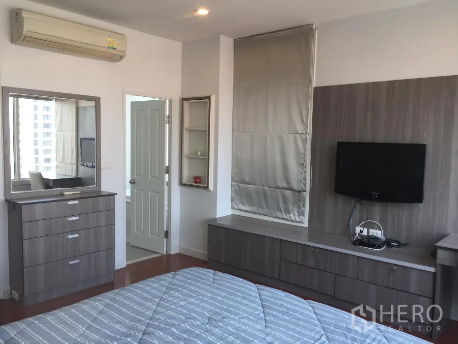 公寓 出租或出售在Khlong Toei, Bangkok - 主卧配灰色定制柜、梳妆台、壁挂电视与空调。