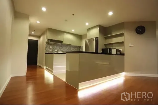 Condominium for rent in Huai Khwang, Bangkok - Modern U-shaped kitchen featuring mosaic backsplash, ample cabinetry and under-cabinet lighting.