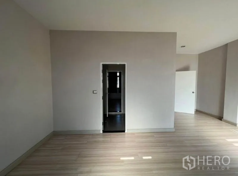 Townhouse for rent or sale in Bang Kho Laem, Bangkok - Master bedroom area with doorway to ensuite and expansive flooring.