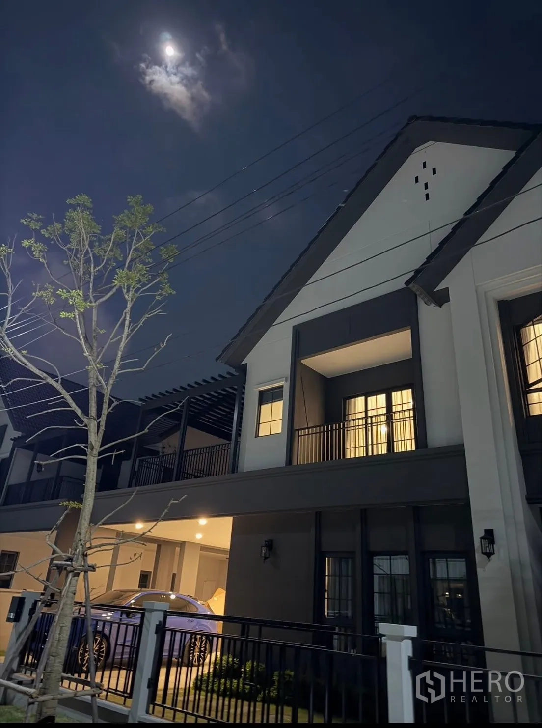 Detached House for rent in Bang Phli, Samut Prakan - Two-storey house exterior at night with balcony, carport, and fence.