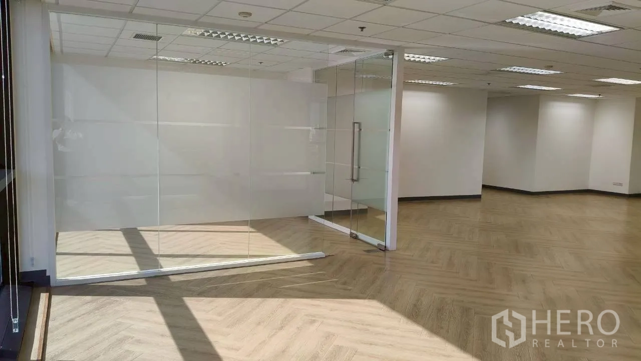 办公空间 for rent in Ratchathewi, Bangkok - 玻璃会议室入口，阳光照射在人字拼地板上