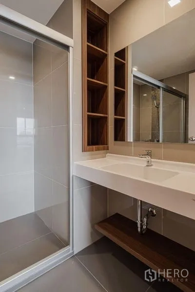 Condominium for rent - Bathroom vanity with wide sink, mirror and wood shelving next to a glass shower enclosure.