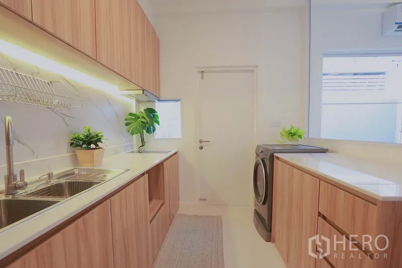 ทาวน์เฮาส์ ให้เช่าในPrawet, Bangkok - ครัวปิดสว่าง ตู้ลายไม้ เคาน์เตอร์หิน อ่างล้างจาน และโซนซักผ้า