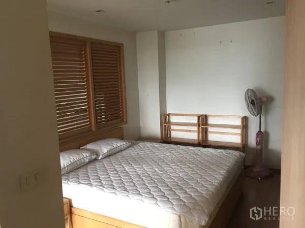 คอนโด ให้เช่าในPathum Wan, Bangkok - ห้องนอนโทนอบอุ่น เตียงขนาดใหญ่ ม่านบานเกล็ดไม้ และชั้นวางของแบบมินิมัล