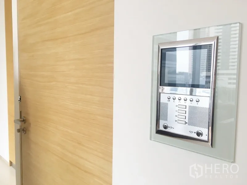คอนโด ให้เช่าในBang Rak, Bangkok - แผงอินเตอร์คอมพร้อมจอภาพติดผนังข้างประตูไม้โทนอ่อน