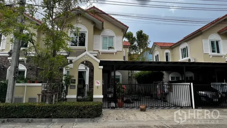 Detached House for rent or sale in Pathum Thani - Two-storey detached house facade with gated driveway and red-tile roof in Mueang Pathum Thani.