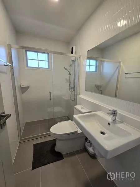 独立式住宅 出租在Bang Phli, Samut Prakan - 现代卫浴，玻璃淋浴间、大镜子、台盆与坐厕。