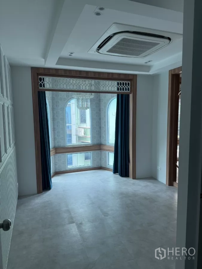 Shophouse for rent - Bright upper-floor room with arched bay windows, ceiling cassette air conditioner, and recessed lighting.