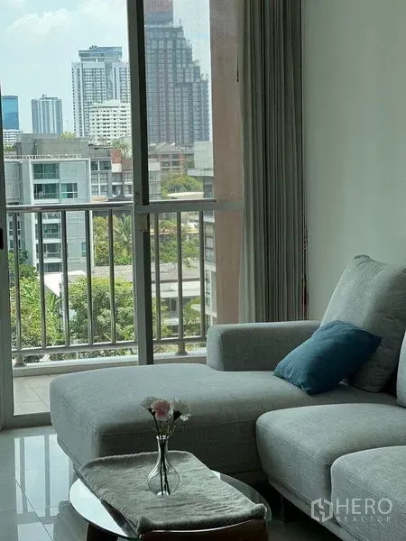 คอนโด ขายในWatthana, Bangkok - ห้องนั่งเล่นโซฟาสีเทาเชื่อมระเบียง กระจกบานใหญ่ชมวิวเมือง