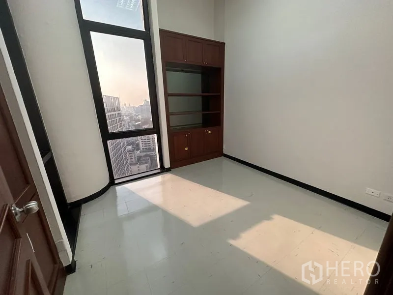สำนักงาน ให้เช่า - ห้องผู้บริหารพร้อมหน้าต่างสูง ตู้บิวท์อินไม้เข้ม และวิวเมือง