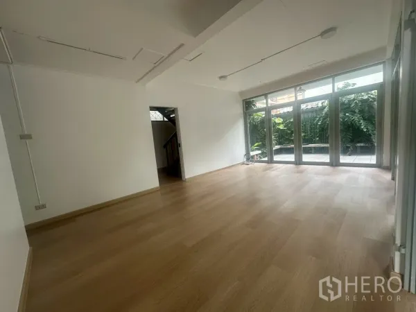 บ้าน ให้เช่าในWatthana, Bangkok - พื้นที่นั่งเล่นแบบโอเพ่นสเปซ มองเห็นสวนผ่านหน้าต่างบานใหญ่ พื้นไม้โทนอ่อน.