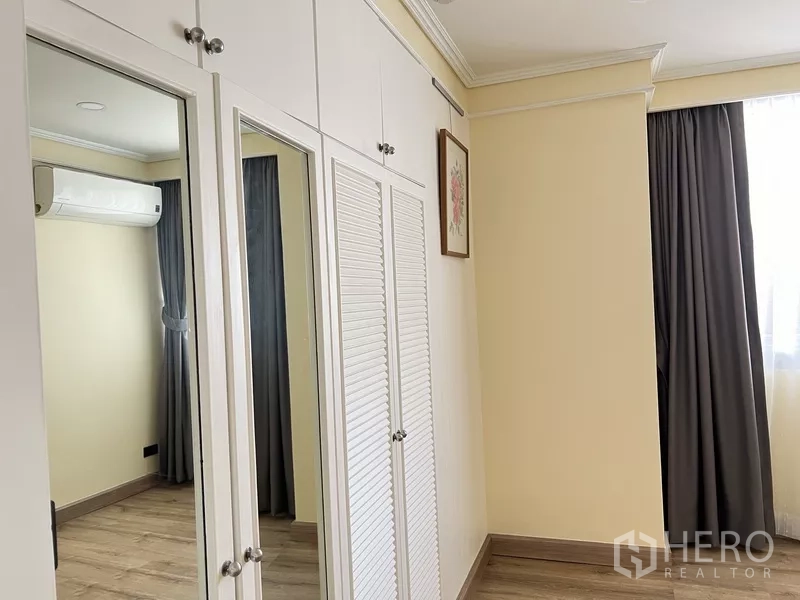 คอนโด ให้เช่าในKhlong Toei, Bangkok - ห้องนอนที่สองพร้อมตู้เสื้อผ้าบิวท์อินสีขาว บานกระจก และเครื่องปรับอากาศ