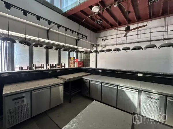 店屋 出租在Bang Na, Bangkok - 吧台服务区，带台下冰柜、吊灯与临街窗面。