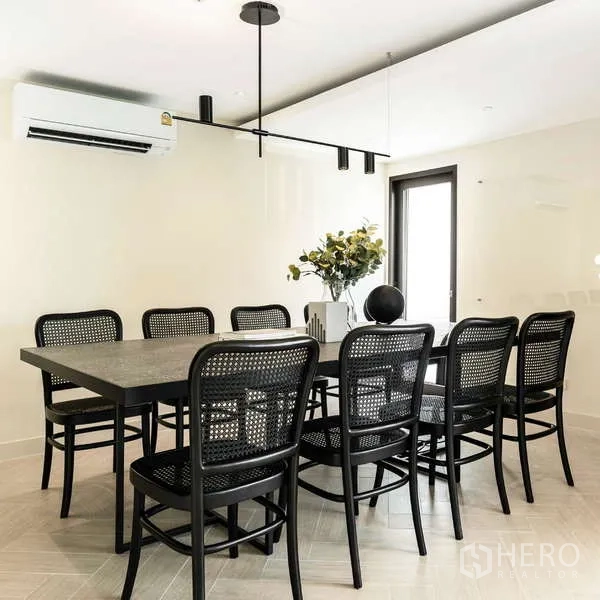 Office Space for rent in Watthana, Bangkok - Boardroom with a large dark table, black rattan chairs, and minimalist pendant lighting.