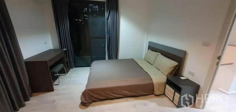 Detached House for rent in Prawet, Bangkok - Bedroom with queen bed, bedside table, and study desk by a window.