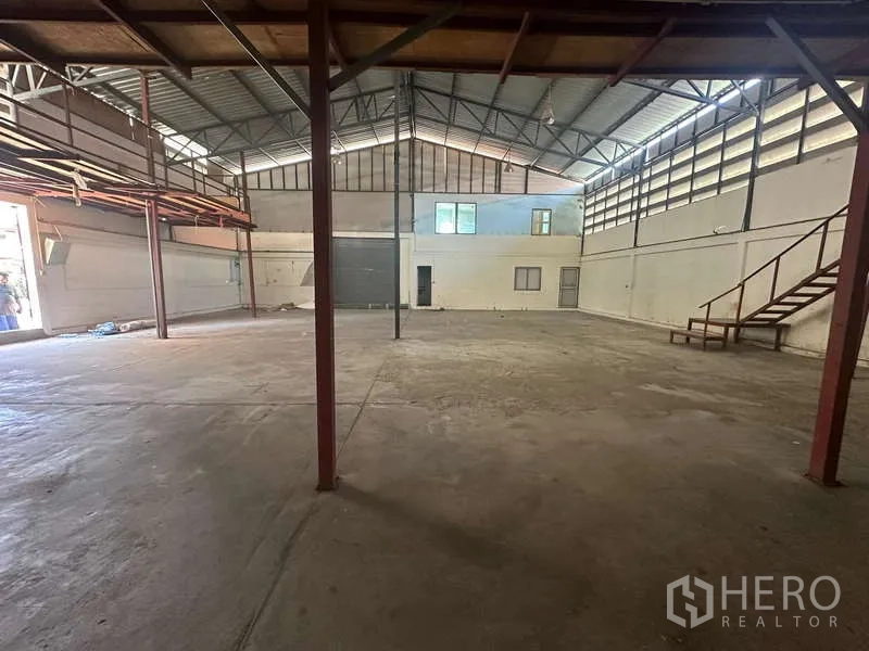 Warehouse for rent in Suan Luang, Bangkok - Wide warehouse bay with ventilation windows, high ceiling and stair access.