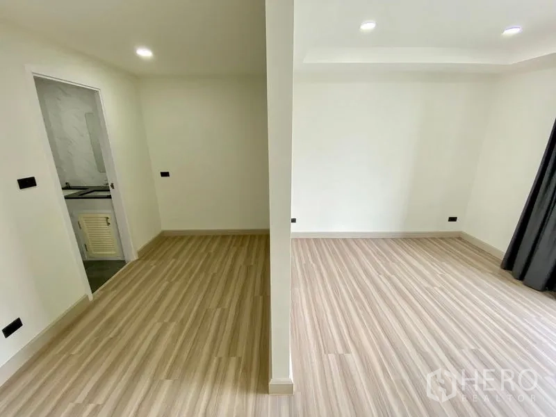 Home Office for rent or sale in Bang Na, Bangkok - Flexible room divided into two sections with an adjacent bathroom and wood-style floors.