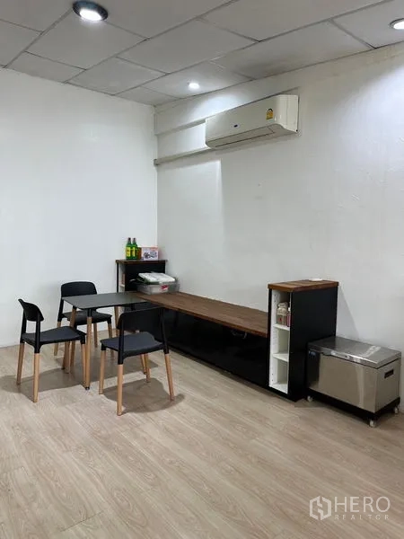 店屋 出租在Khlong Toei, Bangkok - 紧凑的会议角，带小桌、四把椅、长边柜与壁挂空调。