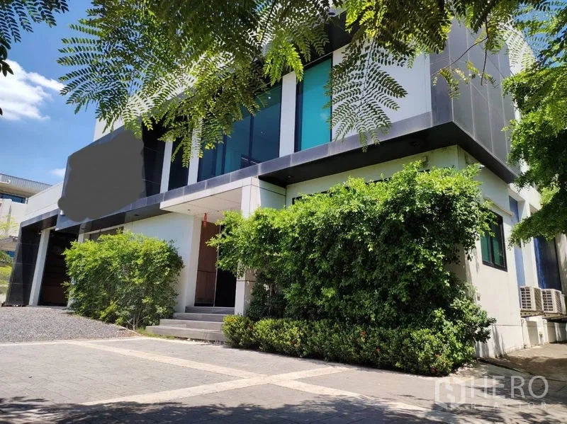 คลังสินค้า ขายในLat Krabang, Bangkok - ด้านหน้าอาคารสำนักงานและโกดังสองชั้น ล้อมด้วยต้นไม้